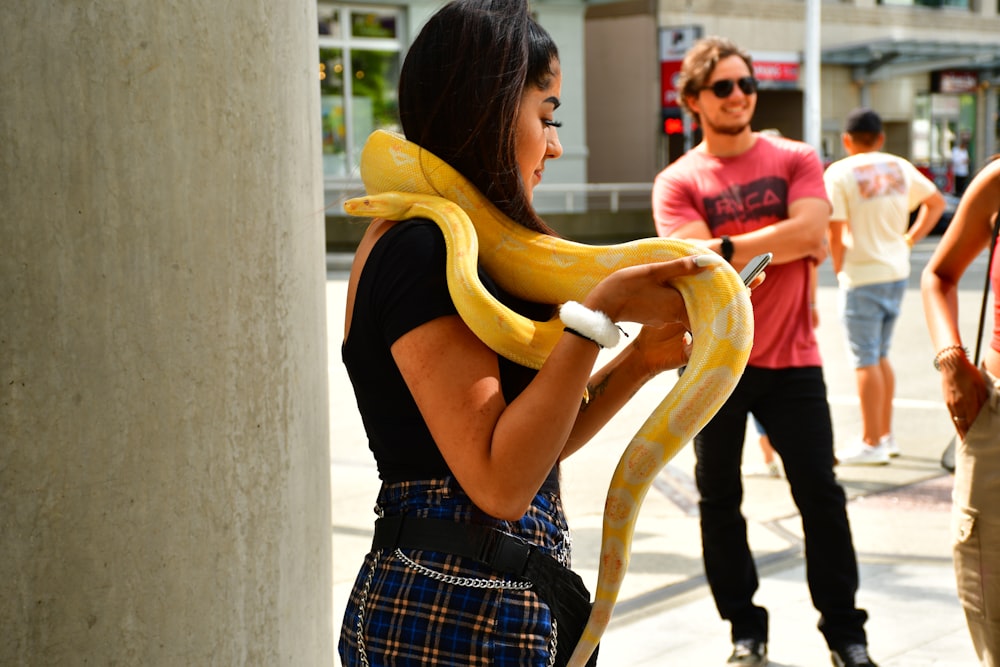 woman carrying yellow snake