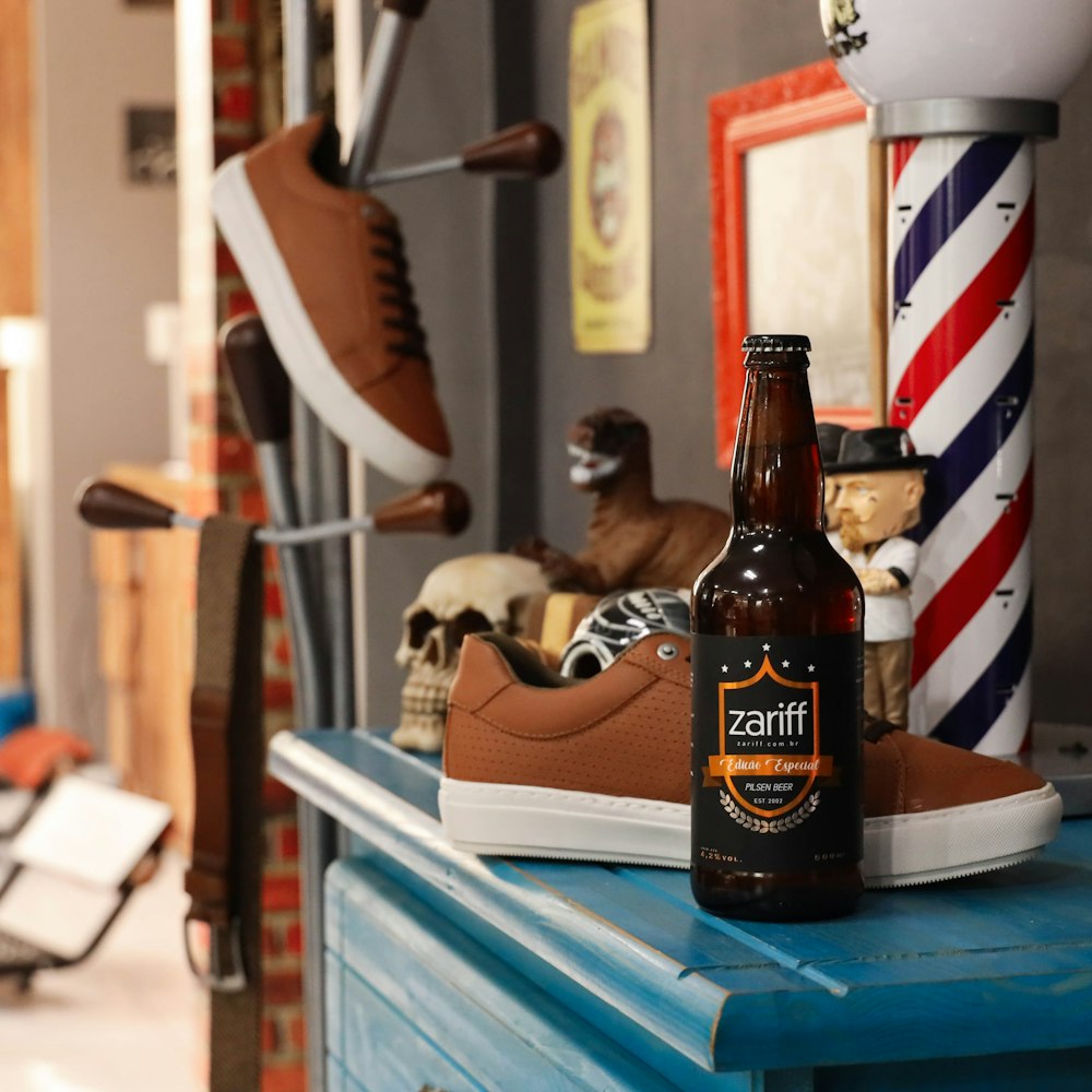 zapato de caña baja y botella de bebida Zariff en la parte superior del gabinete de madera azul