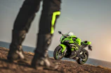 A Honda sportbike speeding along a coastal highway with ocean in the background.