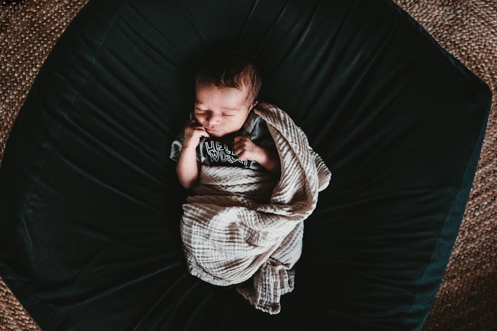 baby lying on black mat