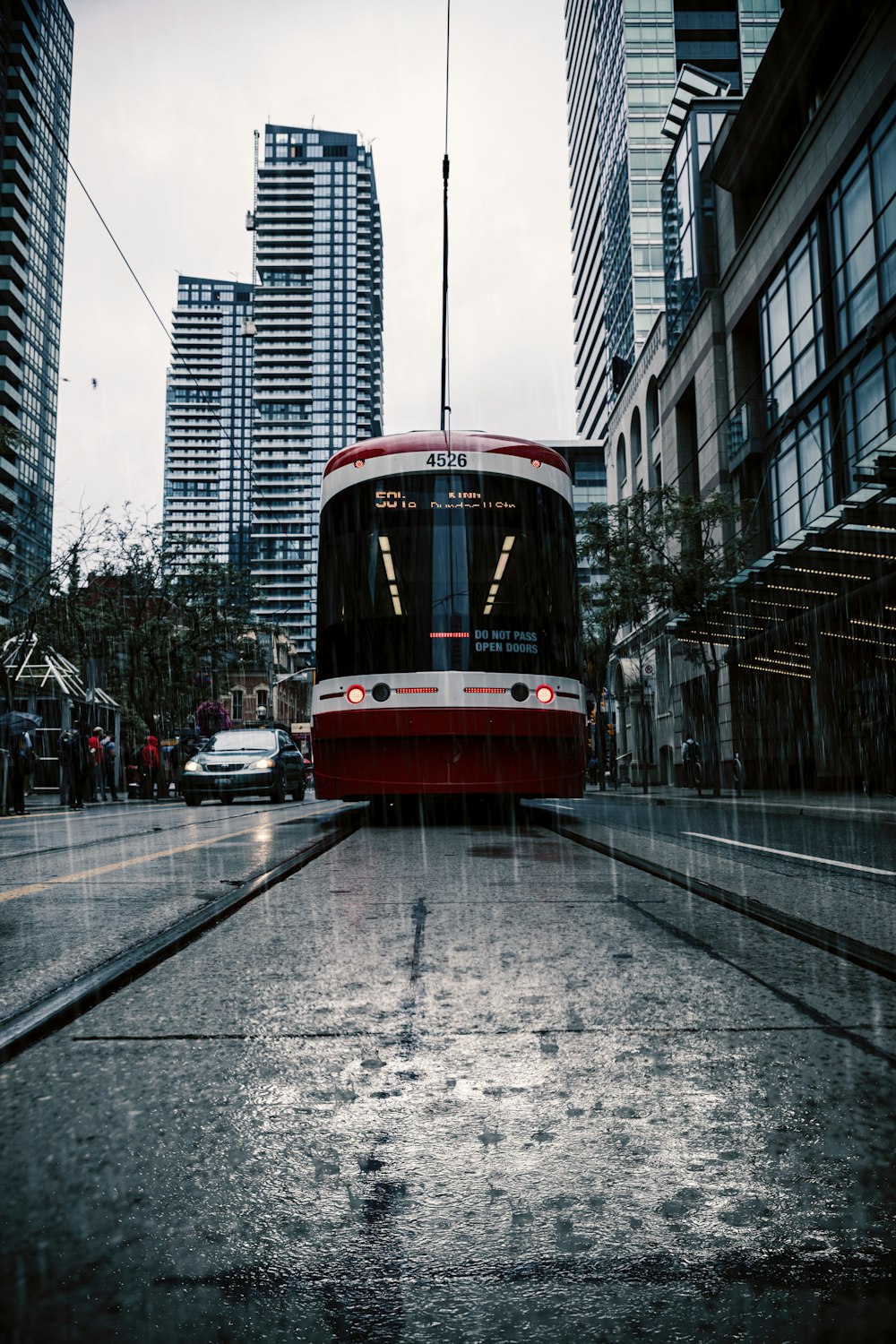 cable train in the middle of the road near car and buildings