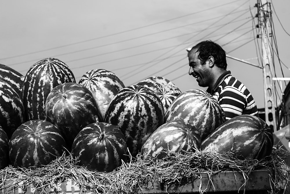 man standing near the watermelon fruit