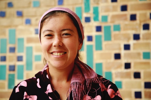 A candid photo of Farzaneh smiling warmly on set, capturing her vibrant personality.