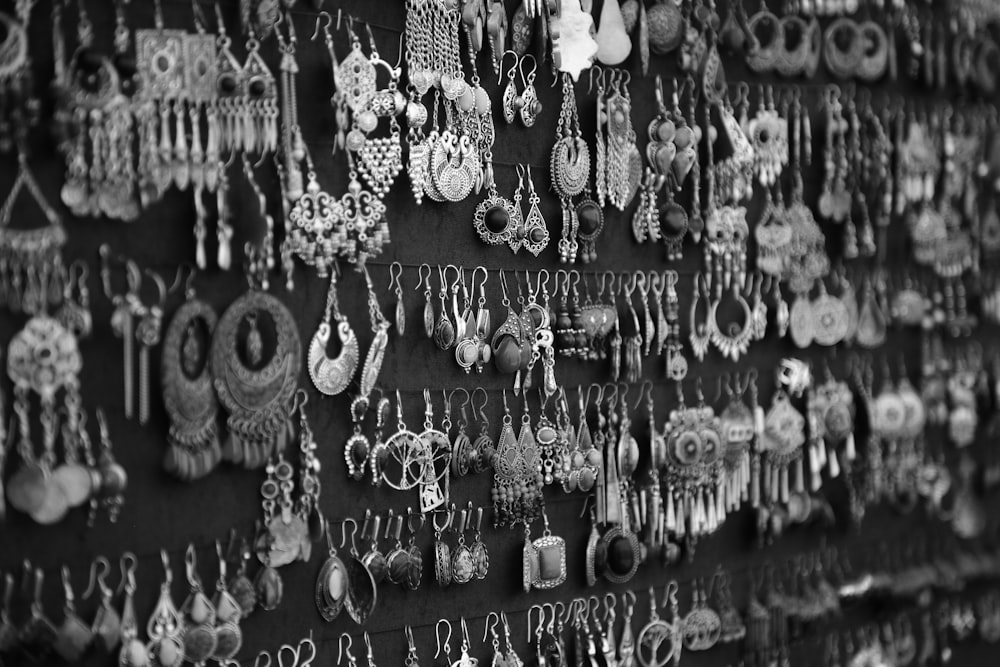 a black and white photo of a wall of earrings