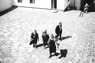 Pilgrims walking together in a peaceful courtyard, bathed in soft morning light.