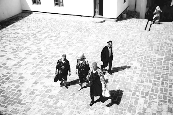 Pilgrims walking together in a peaceful courtyard, bathed in soft morning light.