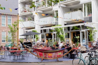 A vibrant dining area of twofloorascafe bustling with happy guests enjoying colorful dishes and fresh drinks.