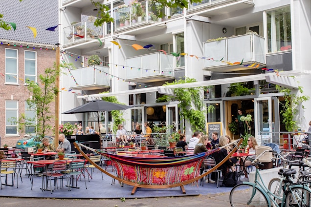 A vibrant dining area of twofloorascafe bustling with happy guests enjoying colorful dishes and fresh drinks.
