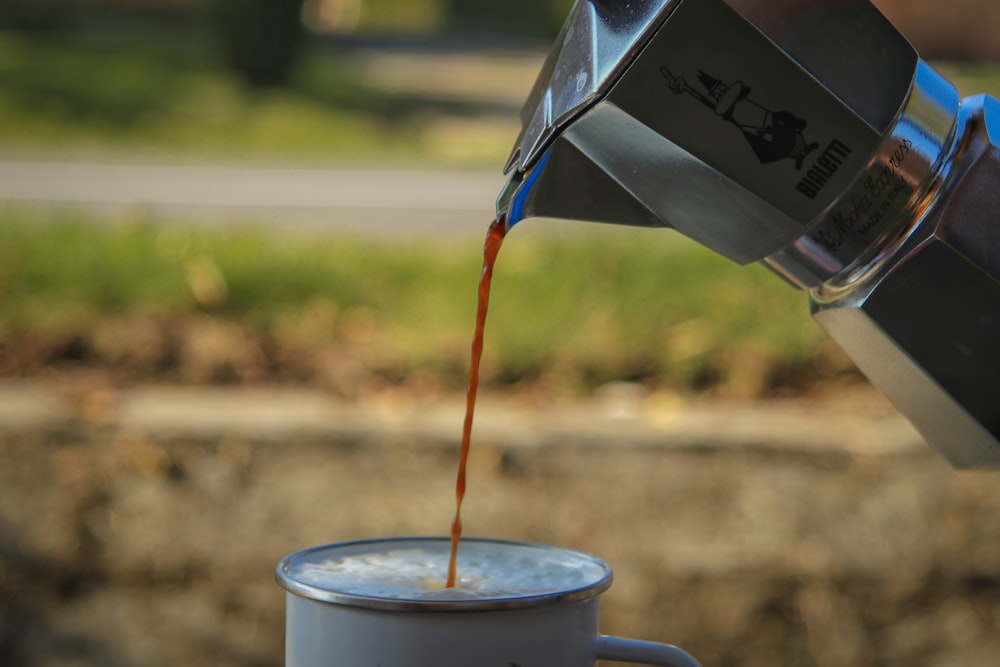 a person pouring coffee into a cup