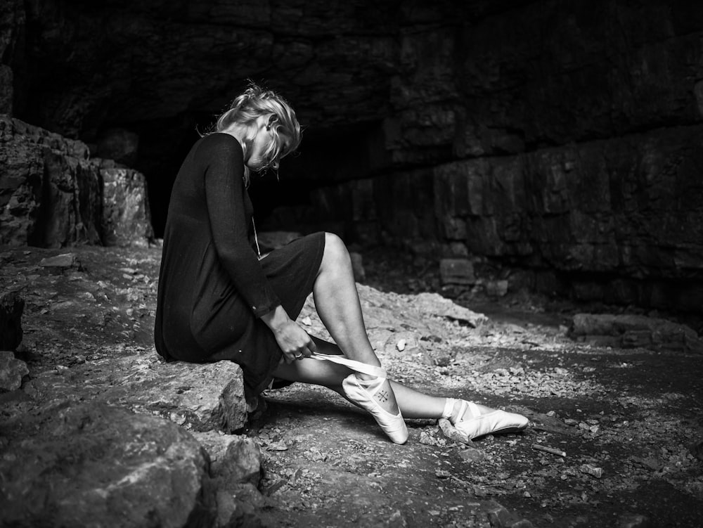 woman sits on rock