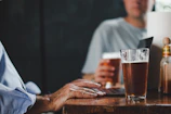 Close-up of members sharing homebrew samples around a rustic wooden table.