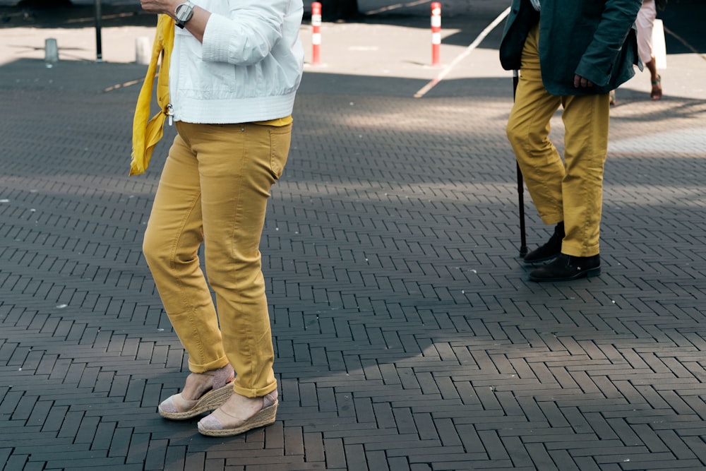 two person standing on gray pavement