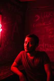 A dimly lit vintage bar corner with a smoky atmosphere and a lone man writing poetry.