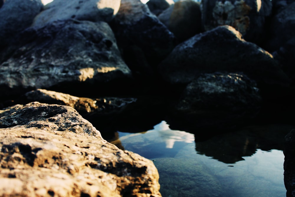 reflection of stones on body of water during daytime