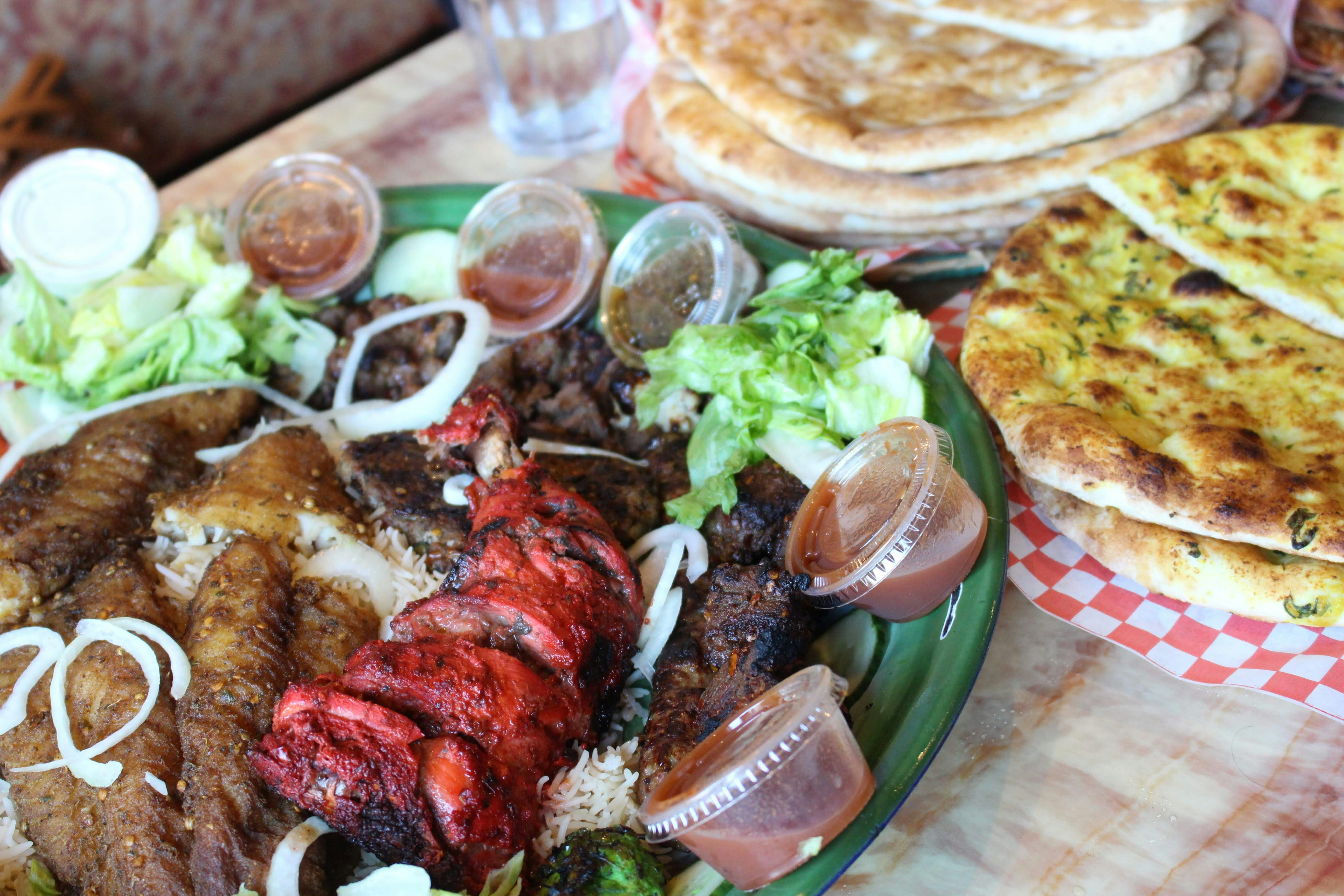 Table with grilled meats, salad and flatbread