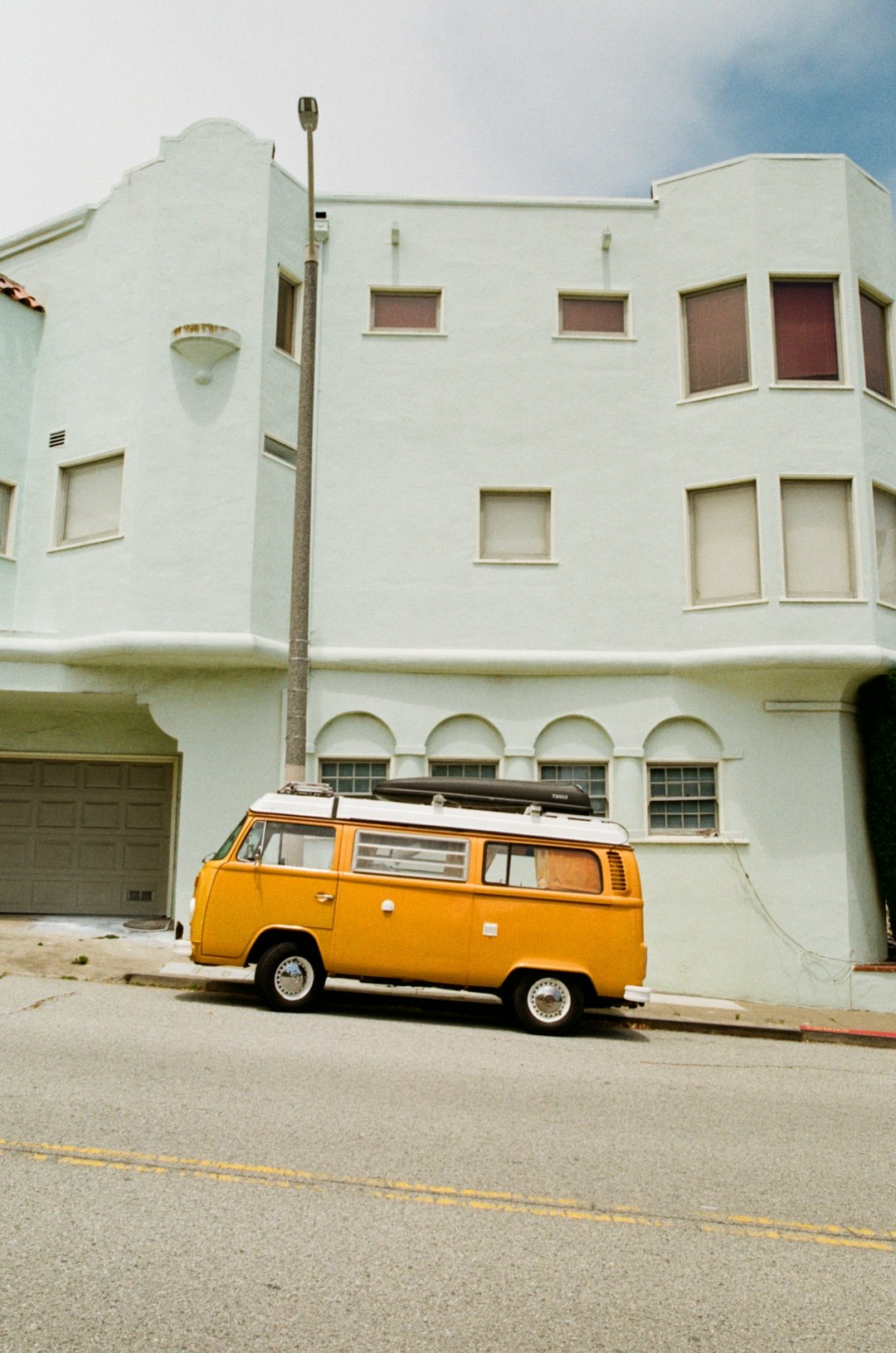 yellow and white van parked near white building