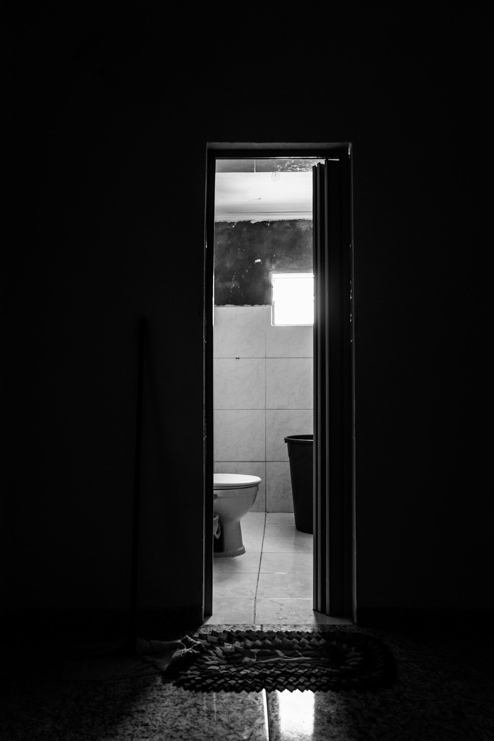 grayscale photography of open door showing toilet bowl