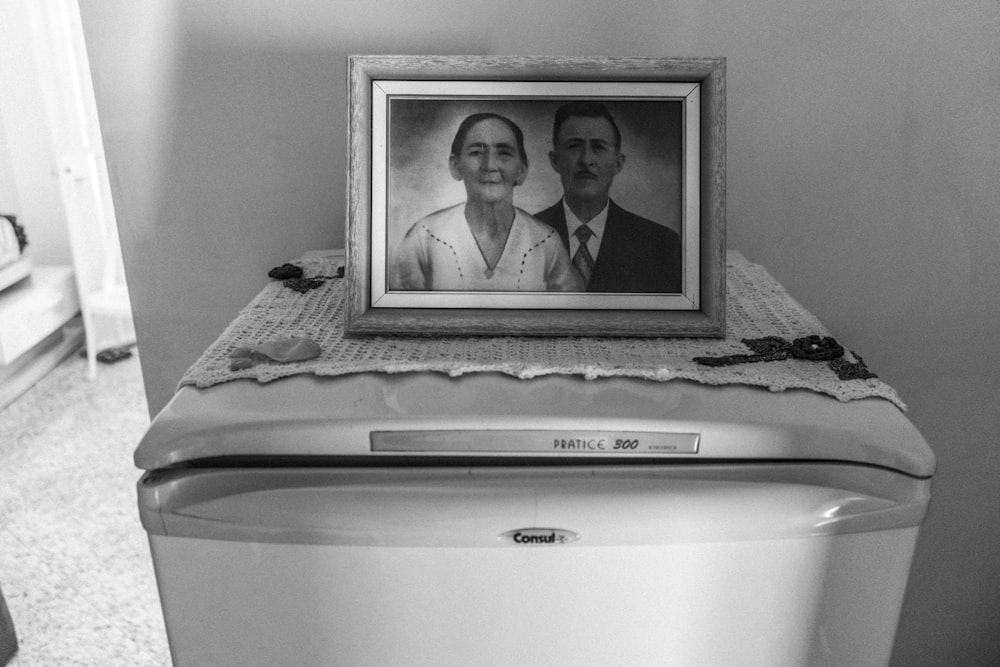 a picture of a man and woman on top of a washing machine