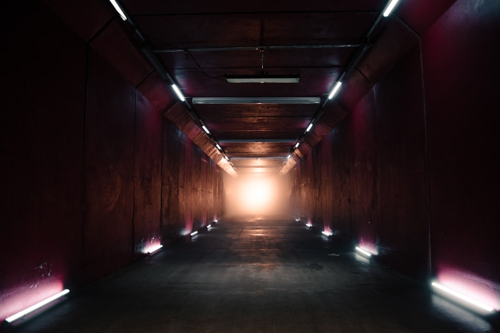 a long hallway with a light at the end of it