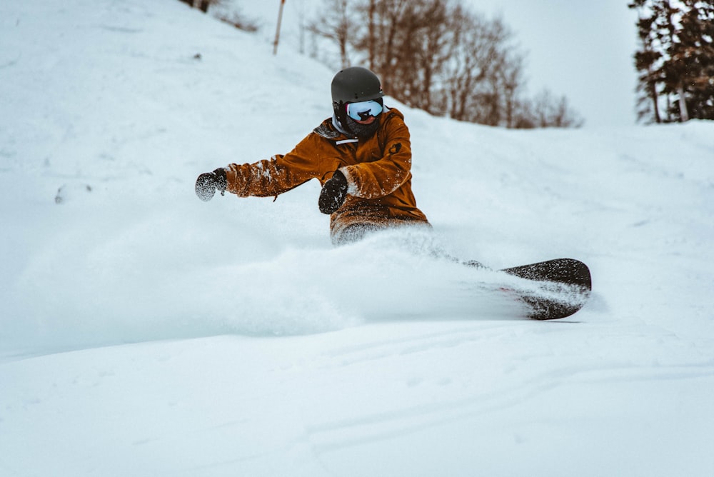 Fotografie einer Person, die tagsüber Snowboard spielt