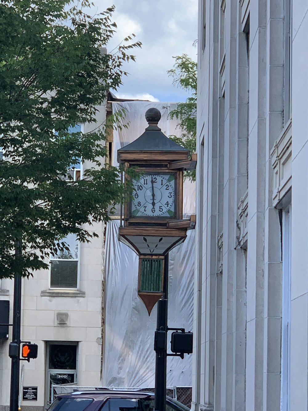 brown and black clock tower on sidewalk