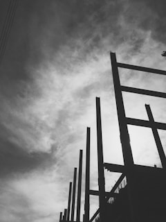 Architectural shot of a construction site at dusk with steel beams silhouetted against a charcoal sky.