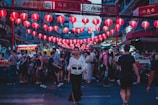 Bustling street market in Osaka glowing with colorful lanterns at dusk.