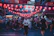 A colorful street market at dusk, glowing with lanterns and bustling with life.