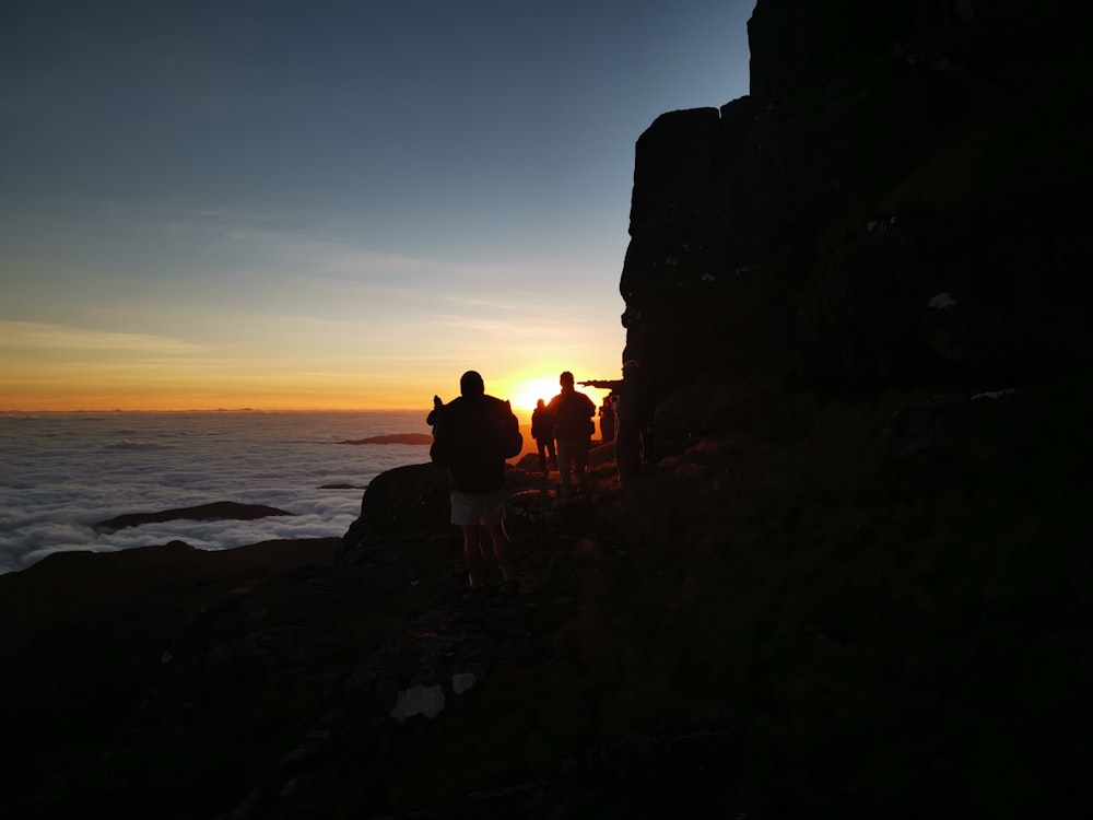 people walking on rock cliff