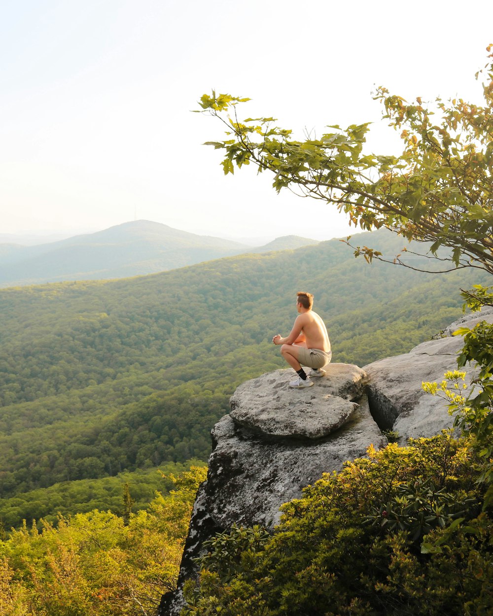 man sitting on rock boulder