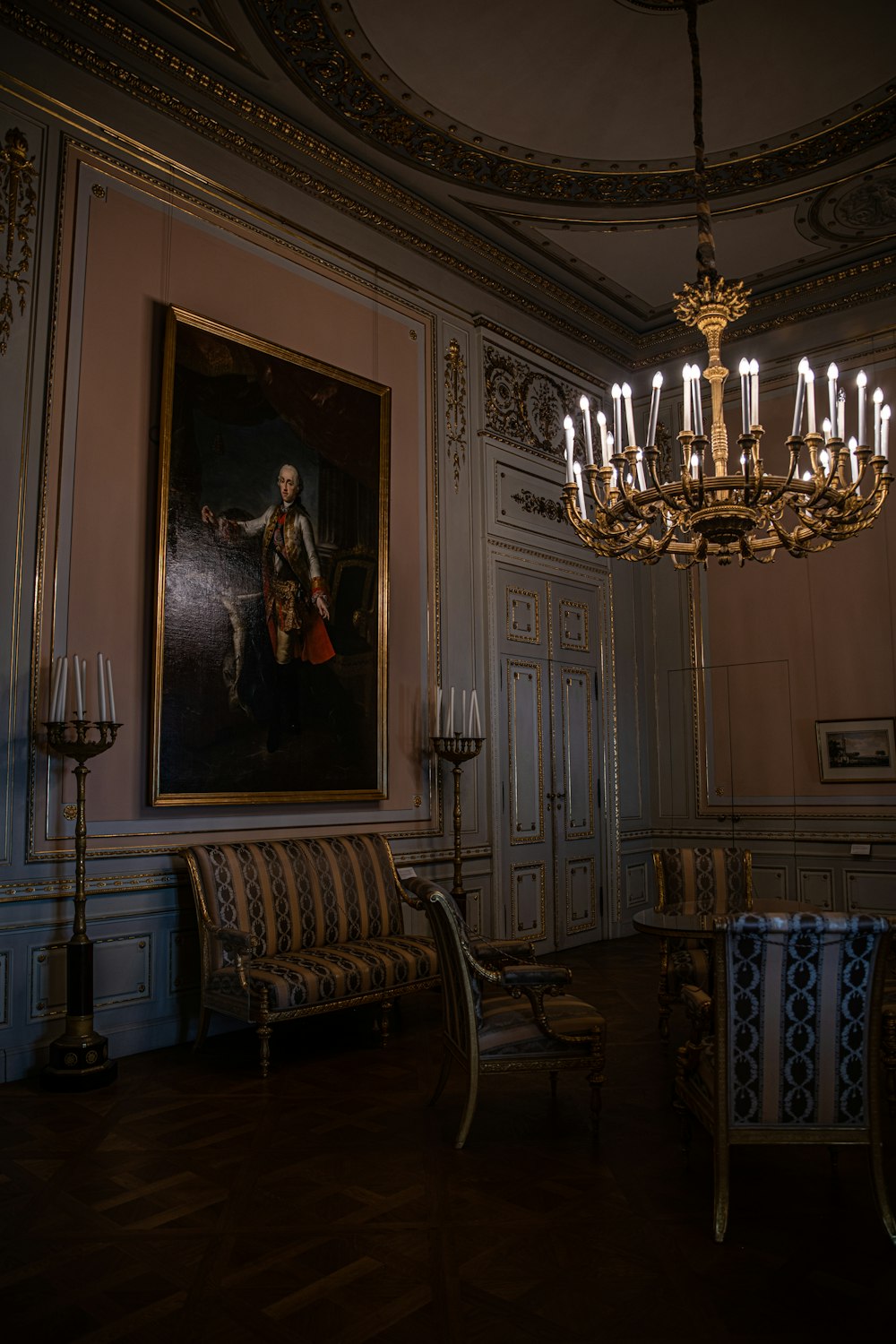a room with a chandelier and a painting on the wall