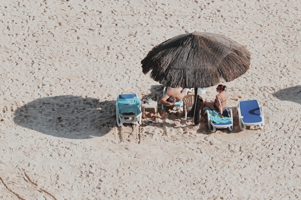 woman sitting on lounger chair beside sea