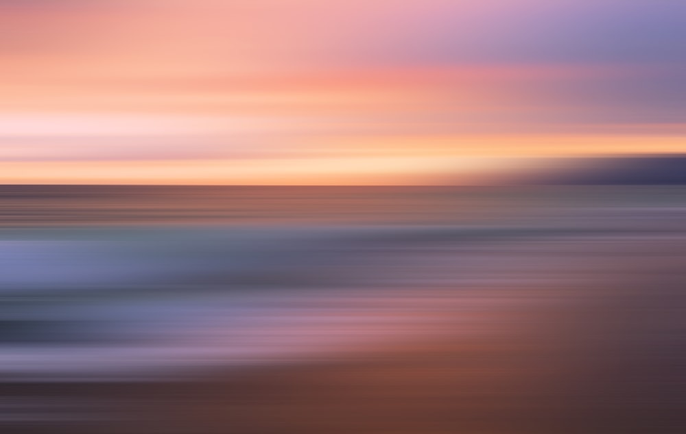 une photo floue d’un coucher de soleil sur l’océan