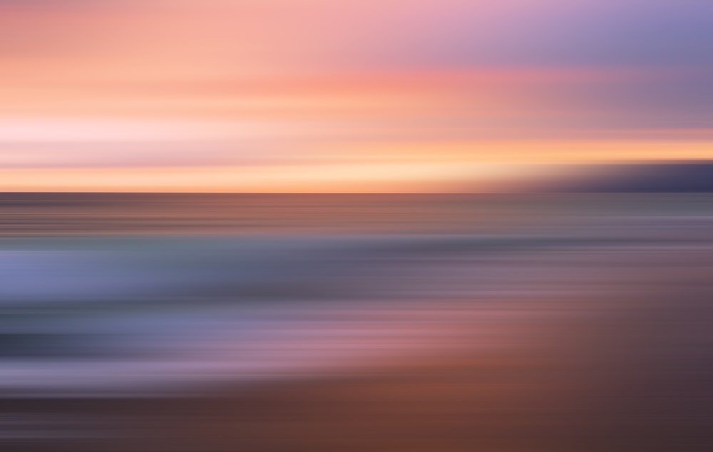 a blurry photo of a sunset over the ocean