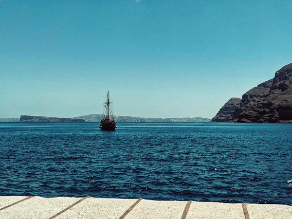 Luxury catamaran sailing the Santorini caldera at sunset