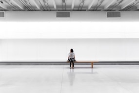 a woman sitting on a bench in a large room