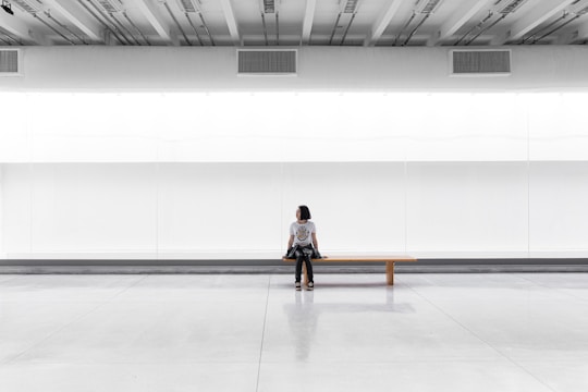 a woman sitting on a bench in a large room