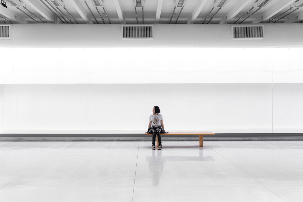 a woman sitting on a bench in a large room