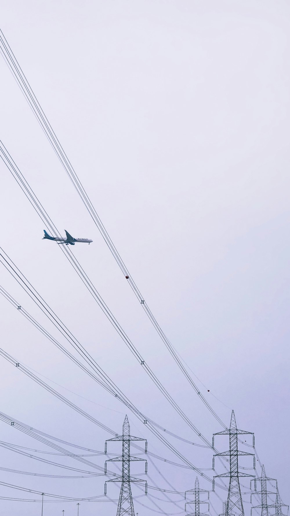 airplane above the electricity transmission post