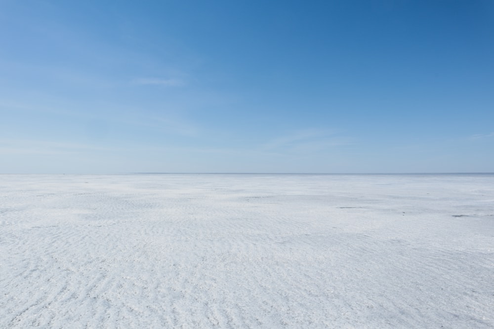 una vasta distesa di sabbia bianca sotto un cielo blu