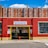 A brick building with large windows serves as a parking garage, featuring a prominent sign labeled 'Ipswich Street Garage'. The facade is painted red with yellow trim around the entrance. Above the garage is a row of tall, red-brick apartment buildings set against a clear blue sky.