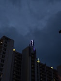 Evening exterior shot showing the building’s illuminated signage against the night sky.