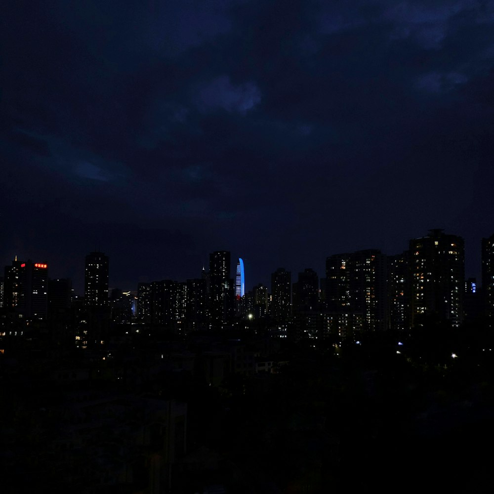 Las luces de la ciudad se encienden por la noche bajo un cielo nublado