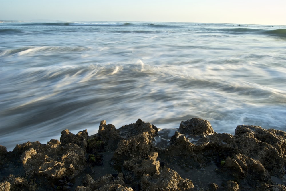 Cuerpo de agua ondulante cerca de rocas marrones