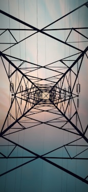 a high voltage power line with the sun in the background