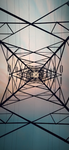 a high voltage power line with the sun in the background