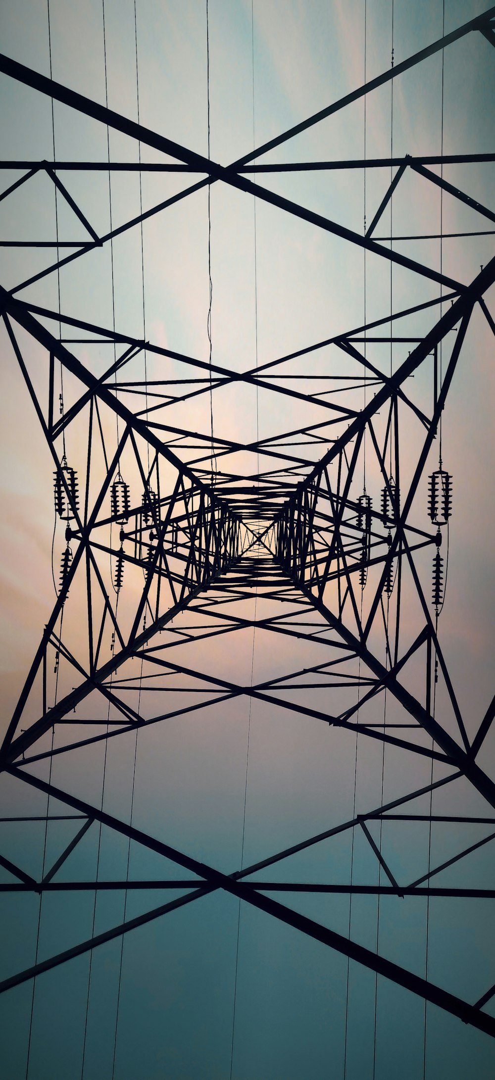 a high voltage power line with the sun in the background