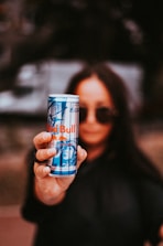 woman holding Red Bull beverage tin can