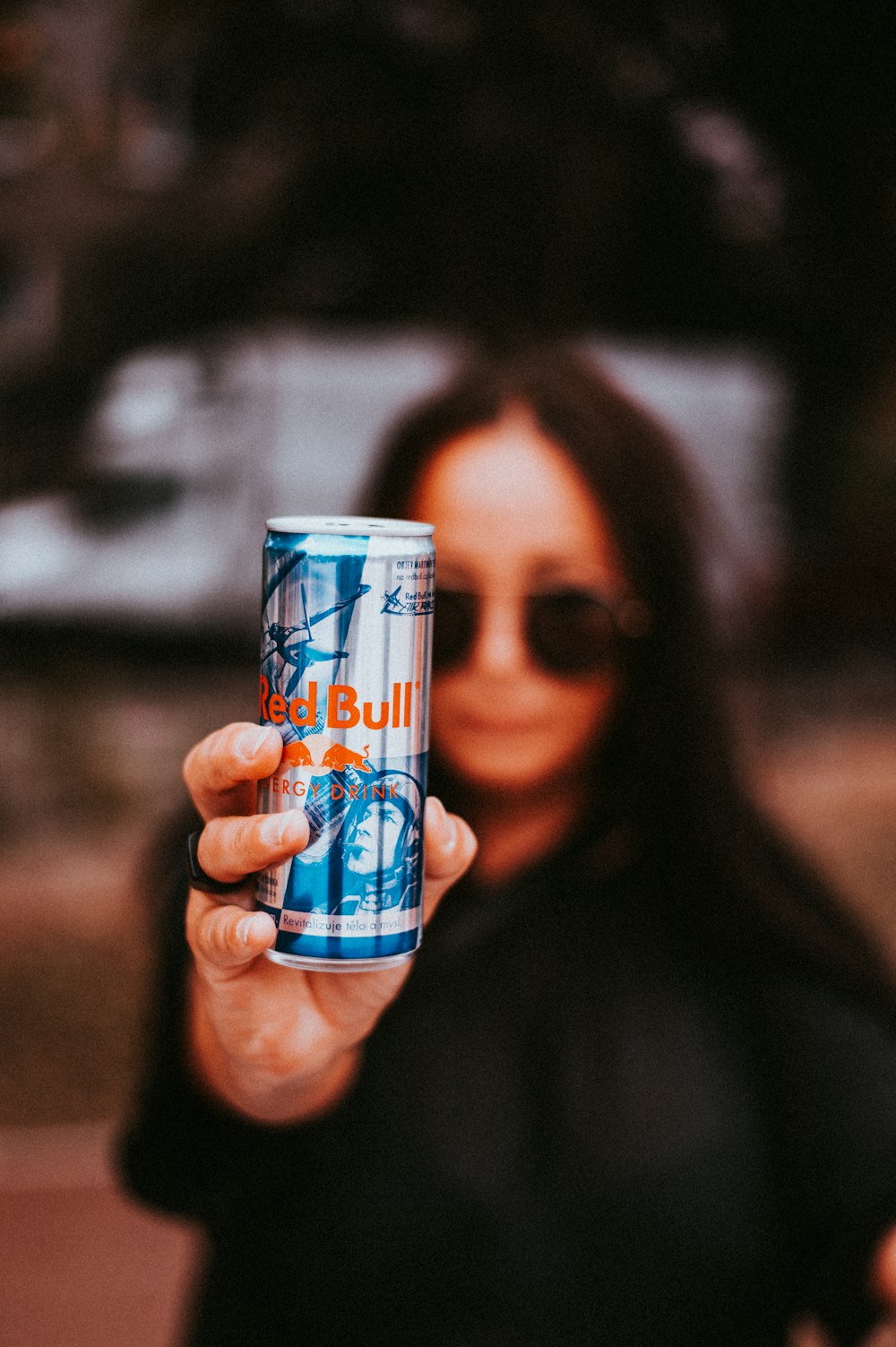 woman holding Red Bull beverage tin can