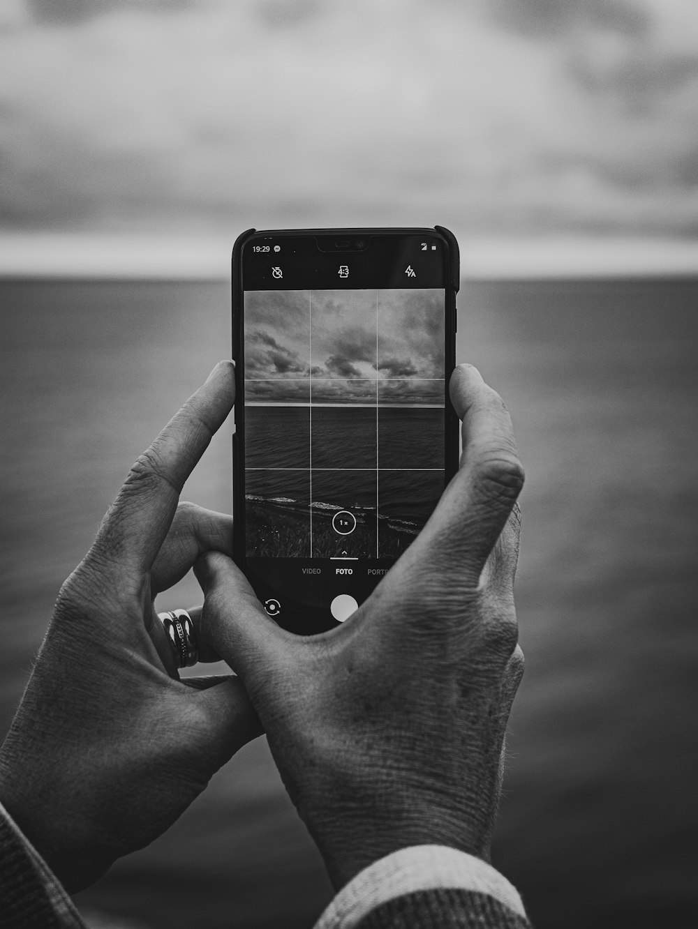 grayscale photography unknown person holding smartphone
